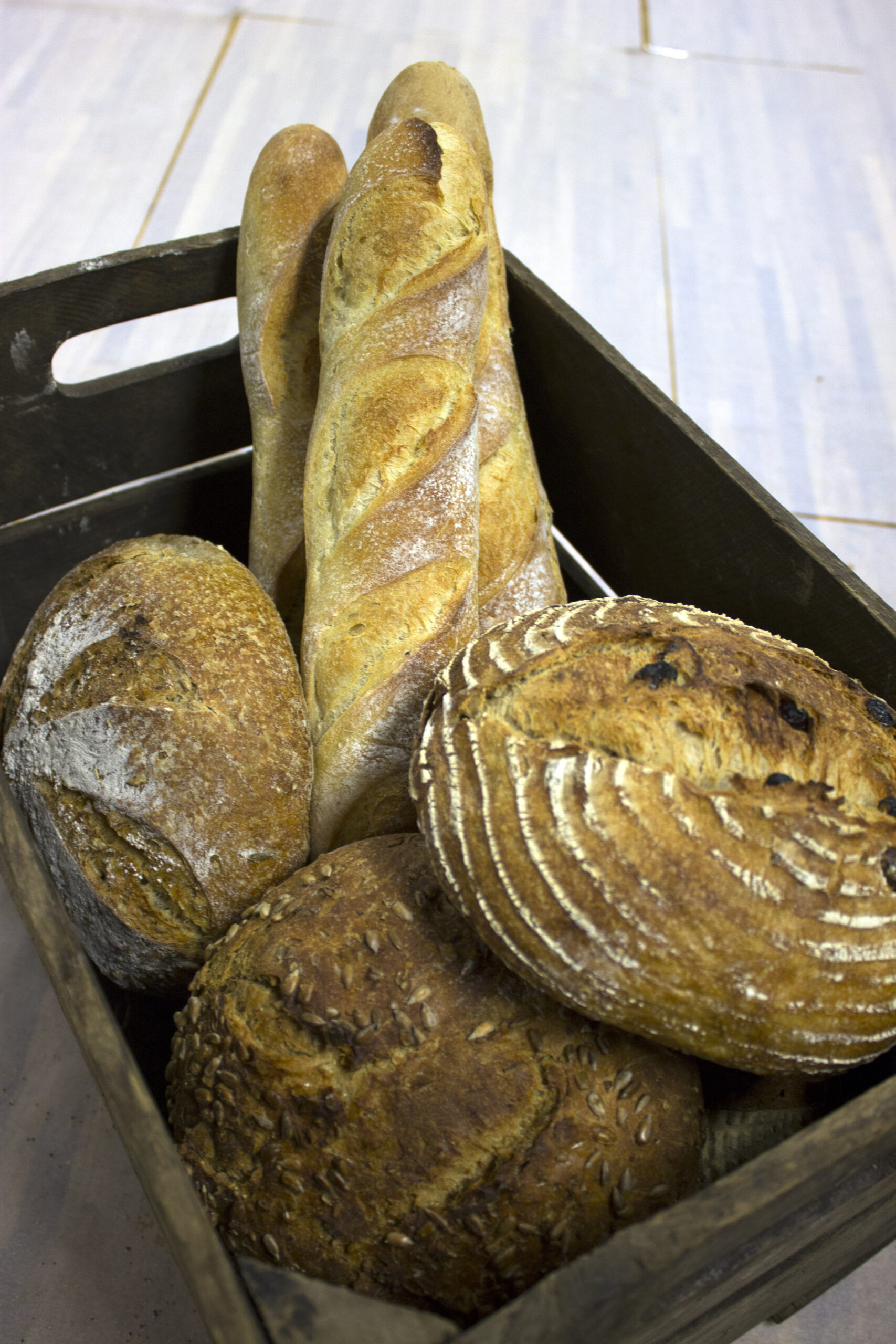 Nýbökuð brauð og baguette í viðarkörfu hjá Mosfellsbakaríi